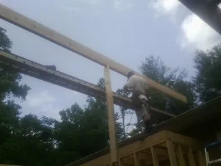 Carpenter setting a ridge beam over a new addition frame — Ice Dam Removal by Roofing Brothers in New Melle
