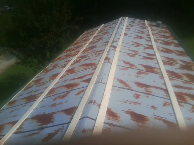 Rusted metal roof panels with new wood purlins before replacement — Storm Damage Roof Repair in New Melle by Roofing Brothers