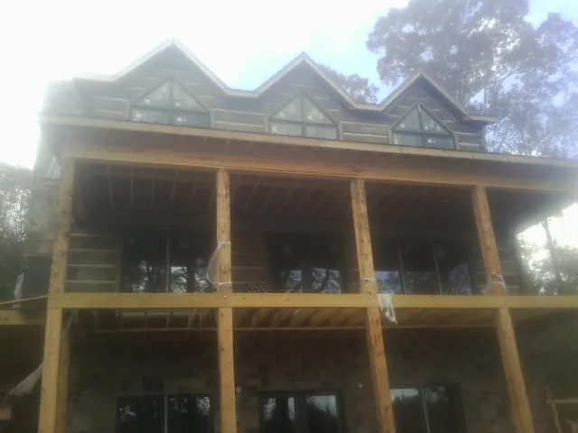 Dormers and porch framing on a large log home under construction — Roof Coating work by our crew in New Melle