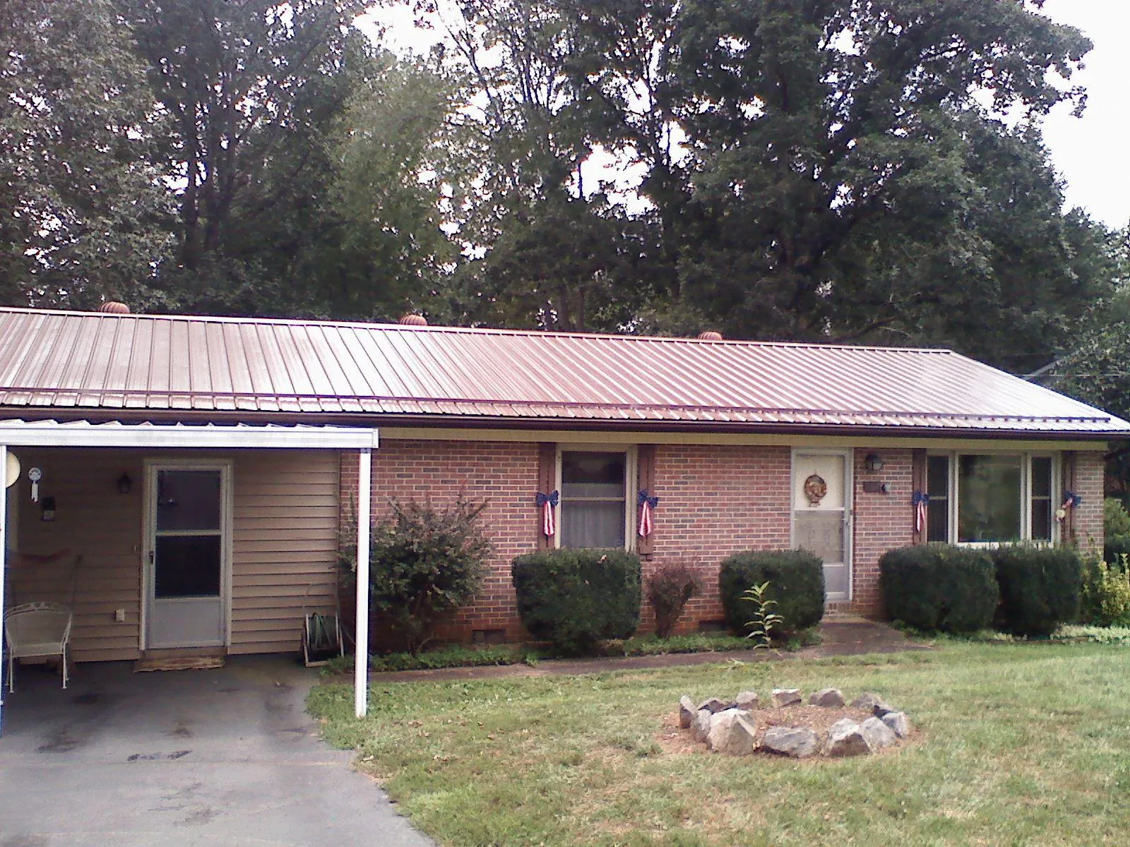 Bronze metal roof and carport on a brick ranch home — Roof Repair work by our crew in New Melle